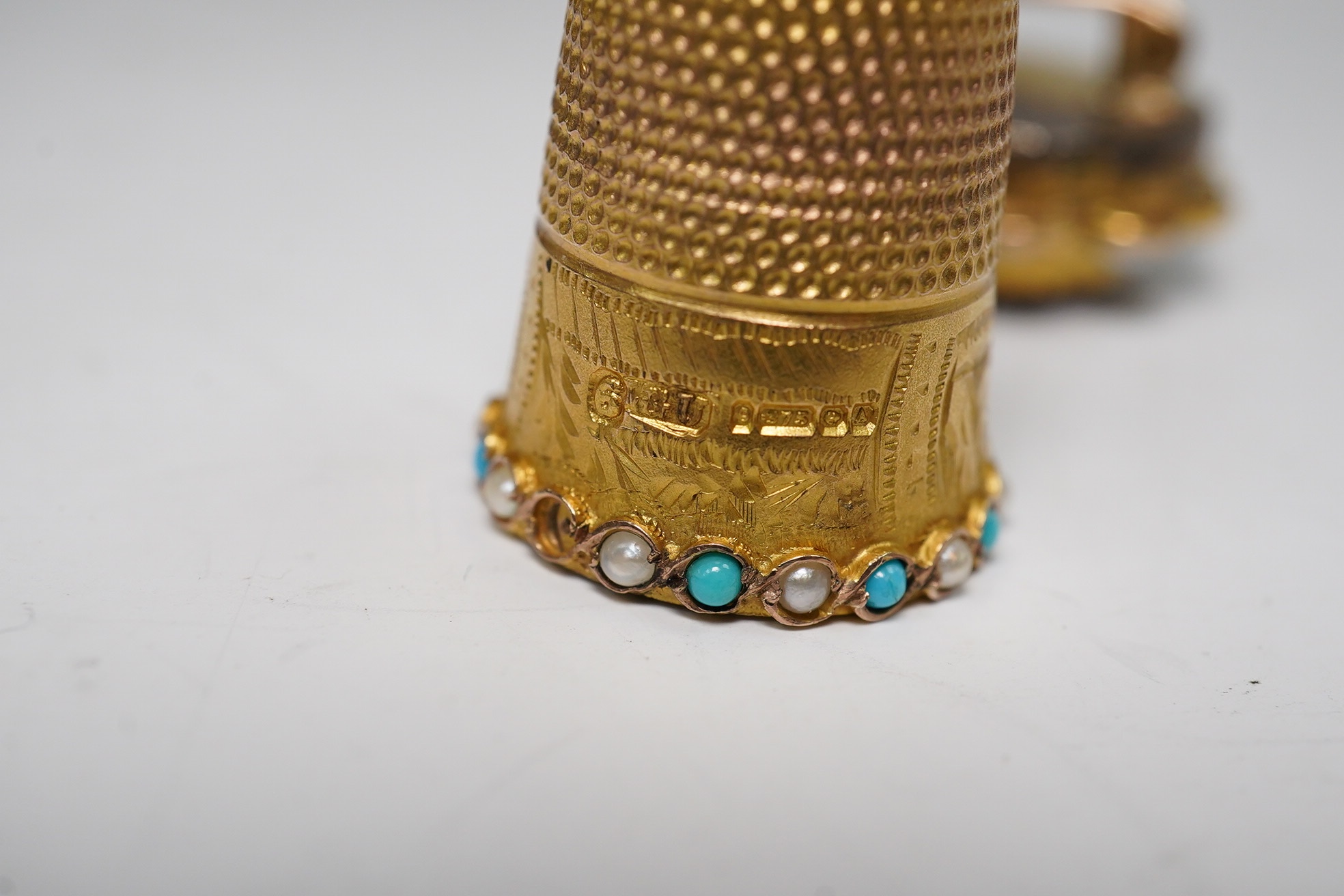 A George V 9ct gold, turquoise and seed pearl set thimble, 5.9 grams, and an amethyst and split pearl set yellow metal clasp, converted to a brooch. Condition - poor to fair